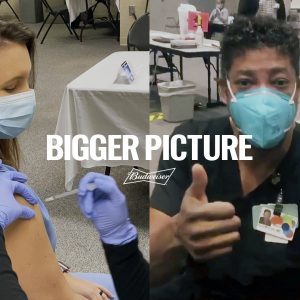 This image provided by Budweiser shows two health care workers getting vaccinated in an advertisement Budweiser is running before the Super Bowl. For the first time since 1983, when Anheuser-Busch used all of its ad time to introduce a beer called Bud Light, the beer giant isn't advertising its iconic Budweiser brand during the Super Bowl. Instead, it’s donating the money it would have spent on the ad to coronavirus vaccination awareness efforts.(Budweiser via AP)