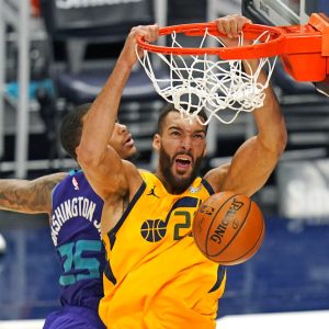 Utah Jazz center Rudy Gobert, right, dunks on Charlotte Hornets forward P.J. Washington (25) in the second half during an NBA basketball game Monday, Feb. 22, 2021, in Salt Lake City. (AP Photo/Rick Bowmer)