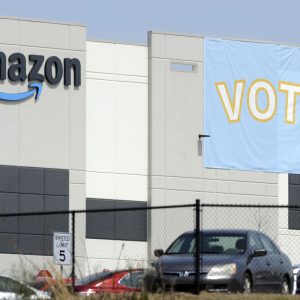 FILE - In this Tuesday, March 30, 2021 file photo, a banner encouraging workers to vote in labor balloting is shown at an Amazon warehouse in Bessemer, Ala.  Vote counting in the union push  in Bessemer is expected to start as early as Thursday, April 8, but hundreds of contested ballots could muddy the outcome if it’s a close race.   (AP Photo/Jay Reeves, File)