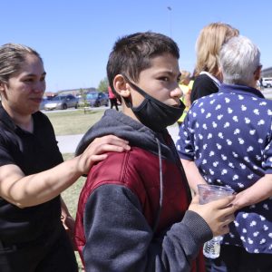 Alela Rodriguez, left, walks with her son, Yandel Rodriguez, 12, at the high school where people were evacuated after a shooting at the nearby Rigby Middle School earlier Thursday, May 6, 2021, in Rigby, Idaho. Authorities said that two students and a custodian were injured, and a male student has been taken into custody. (AP Photo/Natalie Behring)