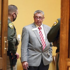 FILE - In this Jan. 12, 2021, file photo, Sen. Anthony Bouchard, R-Cheyenne, chats with Wyoming State Troopers while taking a break during a virtual session of the 66th Wyoming Legislature inside the Senate chamber in Cheyenne, Wyo. Bouchard, a Republican trying to unseat U.S. Rep. Liz Cheney next year, disclosed to supporters in a Facebook Live Video on Thursday, May 20, that he impregnated a 14-year-old girl when he was 18, describing the relationship as “like the Romeo and Juliet” story and saying it was coming to light because of "dirty politics." (Michael Cummo/The Wyoming Tribune Eagle via AP, File)