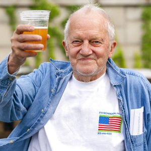In this May 6, 2021 photo, George Ripley, 72, of Washington, holds up his free beer after receiving the J & J COVID-19 vaccine shot, at The REACH at the Kennedy Center in Washington. Free beer is the latest White House-backed incentive for Americans to get vaccinated for COVID-19. President Joe Biden is expected to announce a “month of action” on Wednesday to get more shots into arms before the July 4 holiday.  (AP Photo/Jacquelyn Martin)