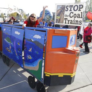 FILE - In this Oct. 17, 2013, file photo, a protester rides in a mock coal train as other protesters demonstrate against trains carrying coal for export moving through Washington state in Tacoma, Wash. The U.S. Supreme Court won't allow Wyoming and Montana to sue Washington for denying a key permit to build a coal export dock. Justices Clarence Thomas and Samuel Alito were in the minority in the ruling Monday, June 28, 2012, against letting the two states sue the third in a case that would have gone directly before the high court. (AP Photo/Ted S. Warren, File)