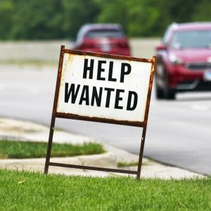 A help wanted sign is displayed at a gas station in Mount Prospect, Ill., Tuesday, July 27, 2021.  The number of Americans applying for unemployment benefits fell last week by 14,000 to 385,000, Thursday, Aug. 5,  more evidence that the economy and the job market are rebounding briskly from the coronavirus recession.(AP Photo/Nam Y. Huh)