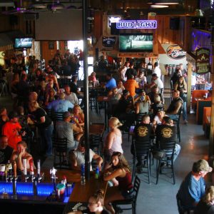 FILE - In this Aug. 7, 2020, file photo, people fill a bar during the Sturgis Motorcycle Rally in Sturgis, S.D. The annual Sturgis Motorcycle Rally refused to take 2020 off despite the threat of the coronavirus pandemic, a decision blamed for leading to a late-summer spike in cases across the Midwest. And it's about to roar right back this year, kicking off Friday, Aug. 6, 2021 with crowds expecting to be significantly larger even as the delta variant is rising. (AP Photo/Stephen Groves, File)