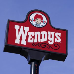 FILE - A sign stands over a Wendy's restaurant, Feb. 25, 2021, in Des Moines, Iowa. Food ads have long made their subjects look bigger, juicier and crispier than they are in person. But some consumers say those mouthwatering ads can cross the line into deception, and that’s leading to a growing number of lawsuits. Burger King is the latest company in the crosshairs. While the case against Burger King was filed in Miami, one of the attorneys who filed it has similar cases pending in New York against Wendy’s, McDonald’s and Taco Bell. (AP Photo/Charlie Neibergall, File)