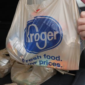 FILE - A customer removes her purchases at a Kroger grocery store in Flowood, Miss., Wednesday, June 26, 2019.   Kroger and Albertsons are selling more than 400 stores and other assets to C&S Wholesale Grocers in an approximately $1.9 billion deal as part of their efforts to complete their merger, Friday, Sept. 8, 2023. (AP Photo/Rogelio V. Solis, File)