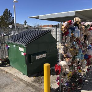 Stuffed animals and notes of condolences are seen attached to a fence Monday, Feb. 22, 2021, around a dumpster at a Cheyenne, Wyo., apartment complex where a 2-year-old boy was found dead. The toddler's body was found in a dumpster several hours after he was reported missing Friday, Feb. 19. (AP Photo/Mead Gruver)