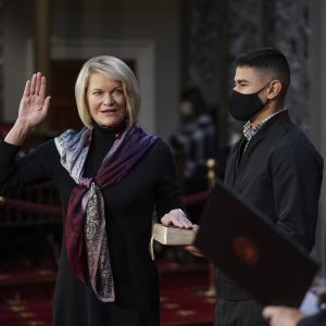 FILE - In this Jan. 3, 2021, file photo, Sen. Cynthia Lummis, R-Wyo., is joined by her nephew Alexandro Giovanni Lozano, as she takes the oath of office from Vice President Mike Pence during a reenactment ceremony in the Old Senate Chamber at the Capitol in Washington. A deepening divide among Republicans over President Donald Trump's efforts to overturn the election runs prominently through Wyoming, the state that delivered Trump's widest prevailing margin by far. Eleven Republican senators saying they will not be voting Wednesday, Jan. 6, 2021 to confirm President-elect Joe Biden's victory include Wyoming's newly sworn in Sen. Lummis, a Cheyenne-area rancher and former congresswoman. (AP Photo/J. Scott Applewhite, Pool, File)